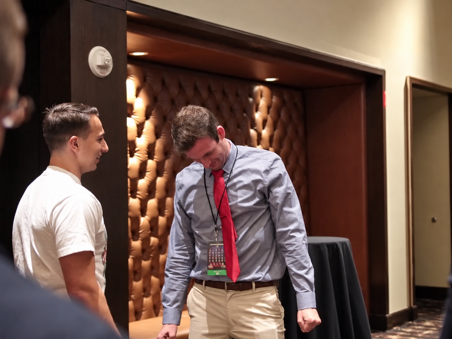 Tyler beside a participant with a deeply bowed head during a conference demonstration.