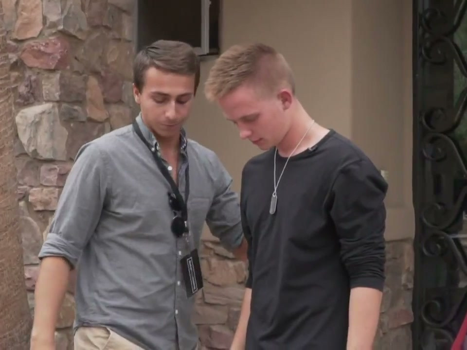 Tyler beside a participant with their head lowered and eyes closed during a hypnosis demonstration.