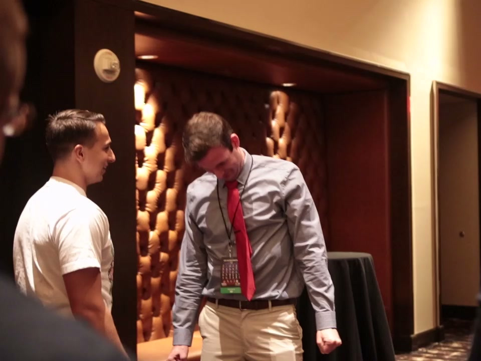 Tyler beside a participant with a deeply bowed head during a conference demonstration.